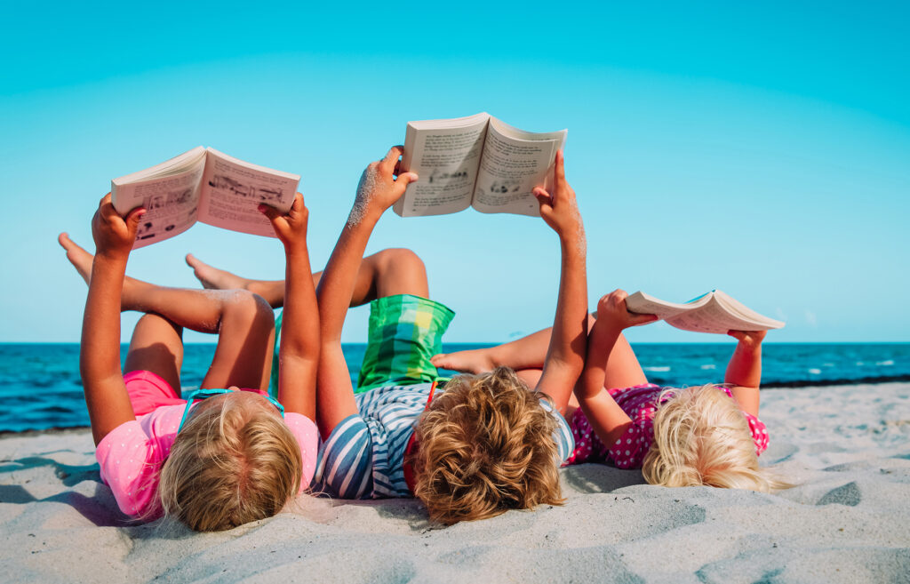 children reading on the beach