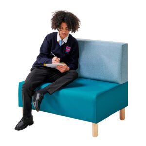 Teenager sitting and reading on double seat in school library