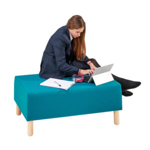 teenager reading and sitting on two seater in school library