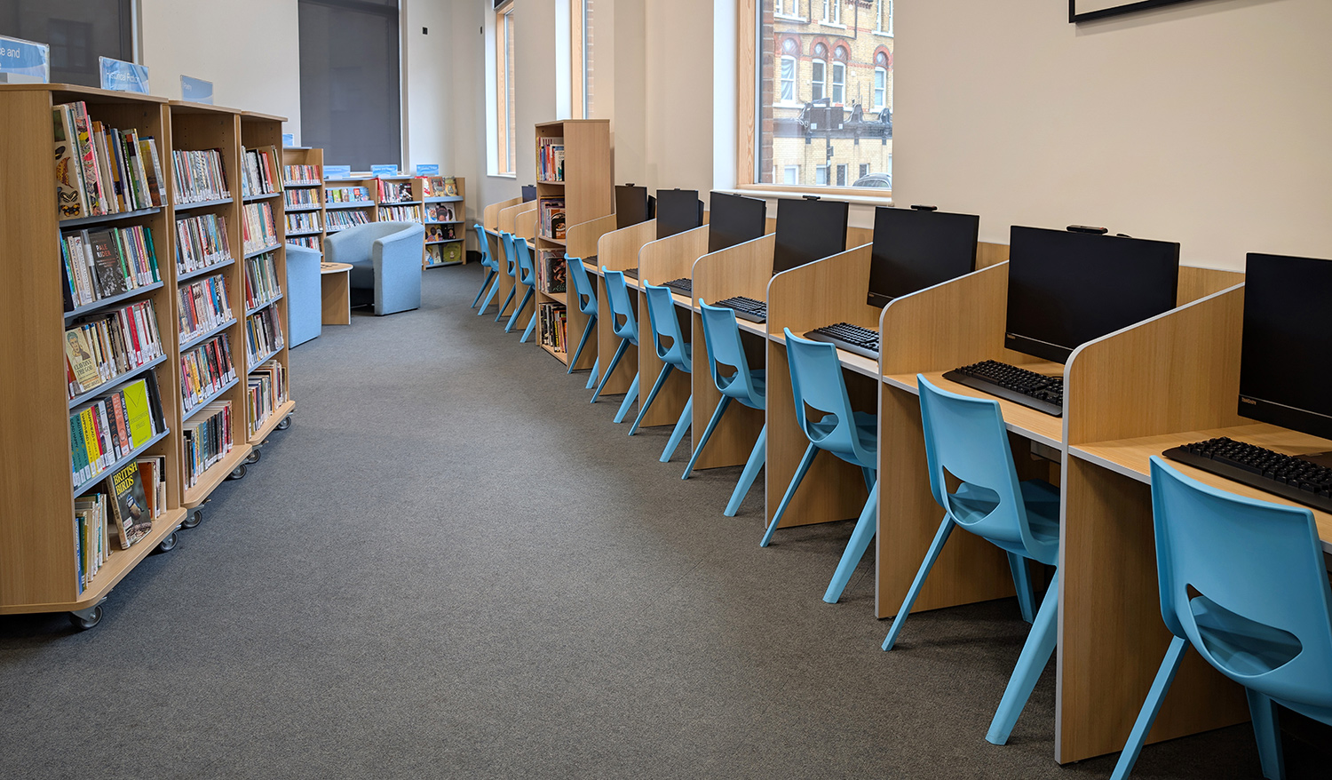 secondary school library with study desks mobile library shelving soft-seating