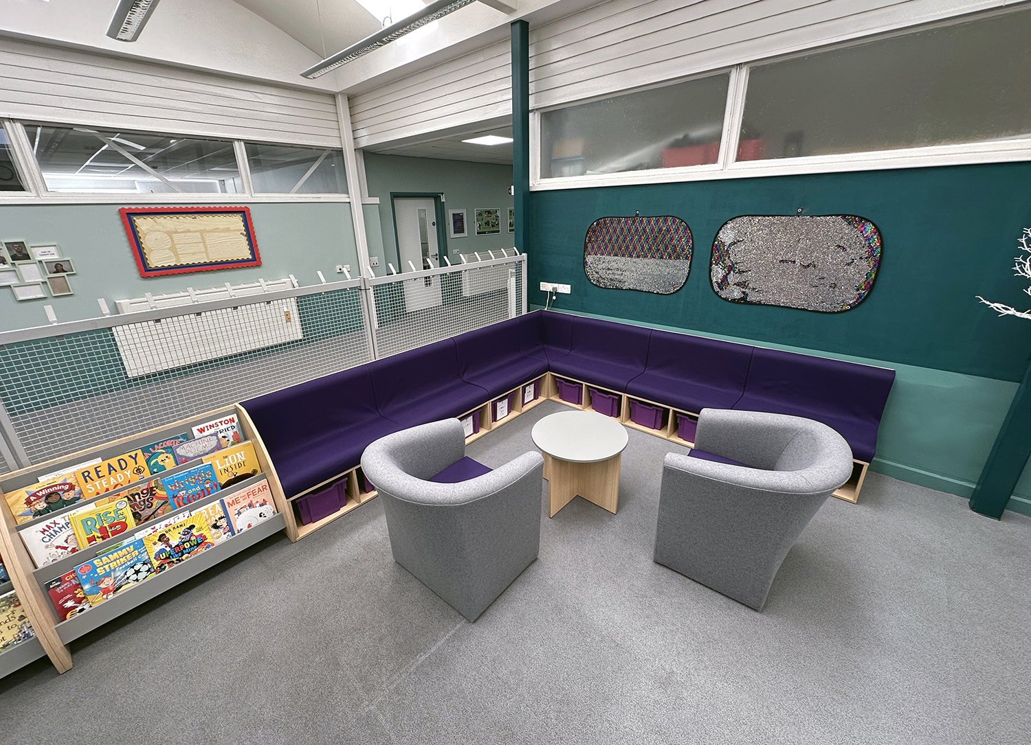 corner seating in school with book display armchairs and coffee table