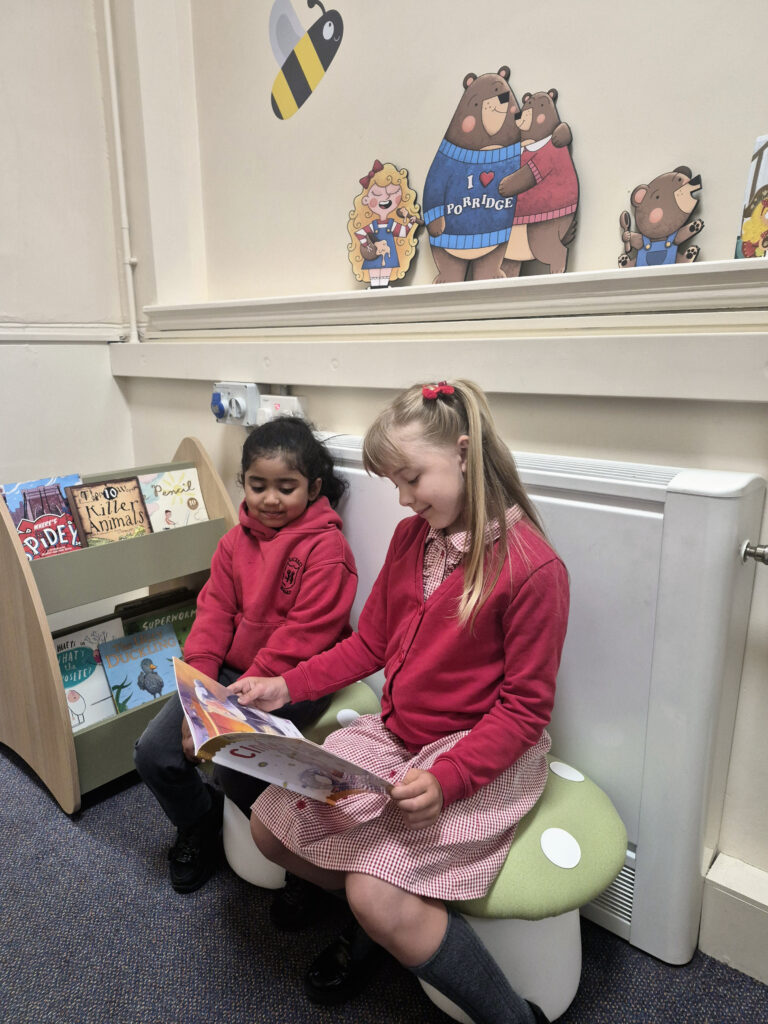 girls reading book in school library