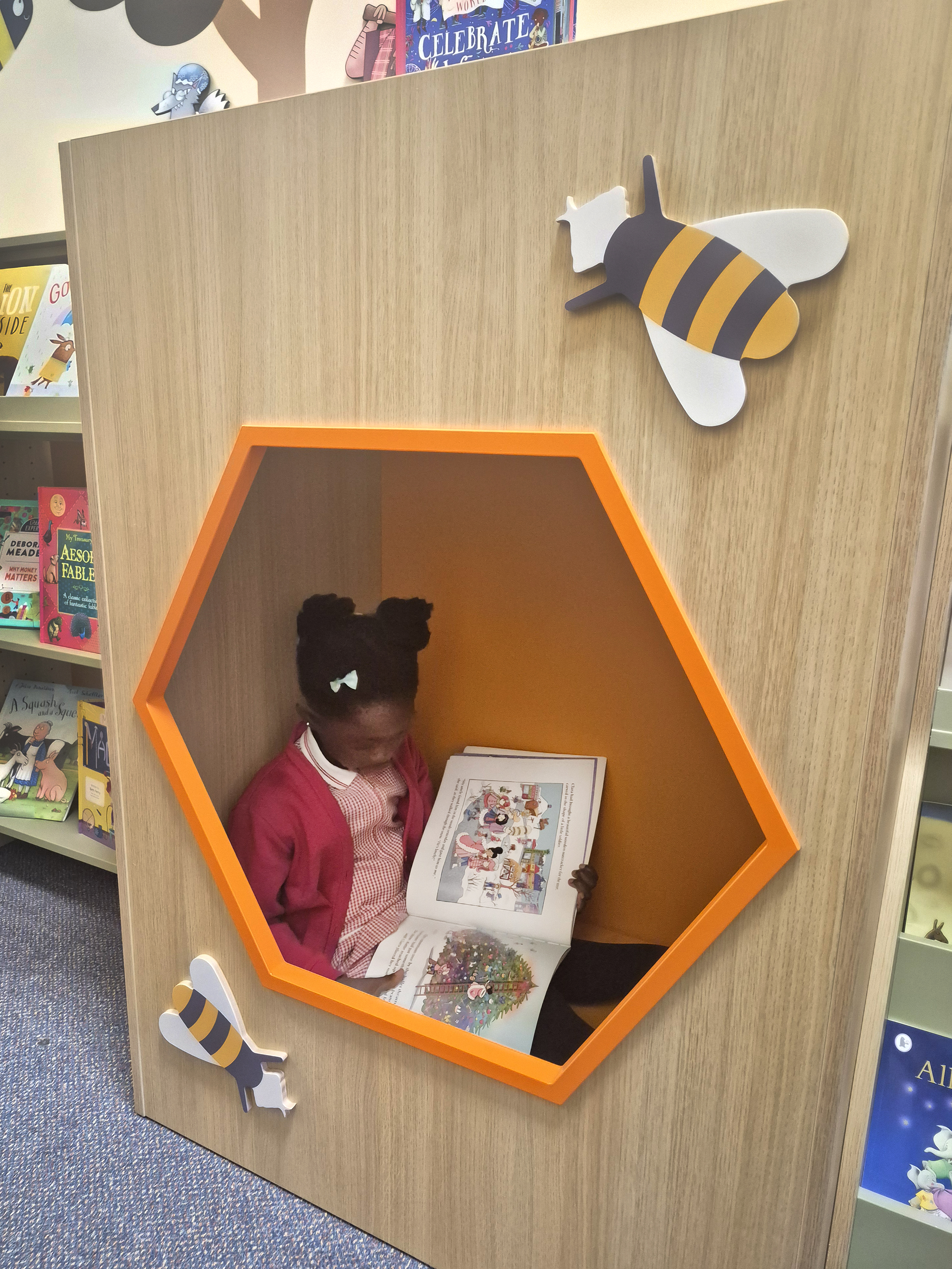 girl reading picturebook in beehive reading nook